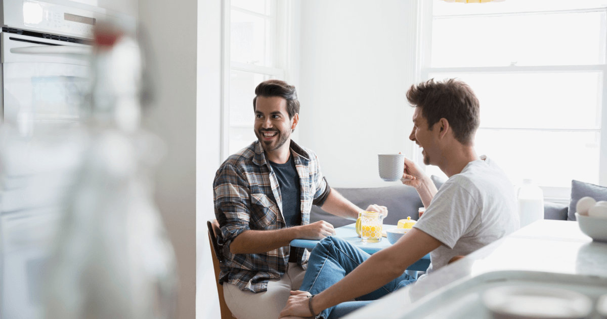 two men conversing in kitchen