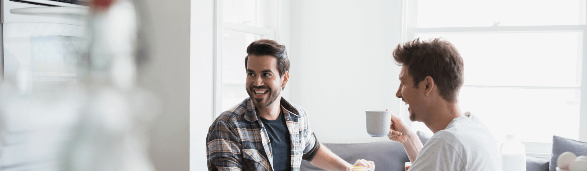 two men conversing in kitchen